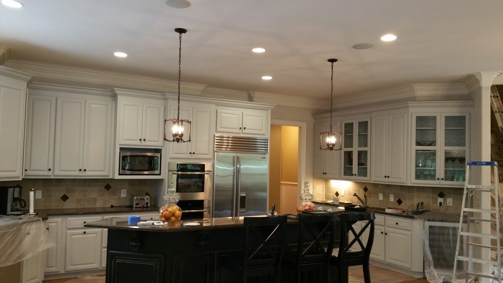 Modern kitchen with freshly painted white cabinets and black island, showcasing Dubon Painting and More Inc.'s expertise in painting services in Fort Mill, SC.