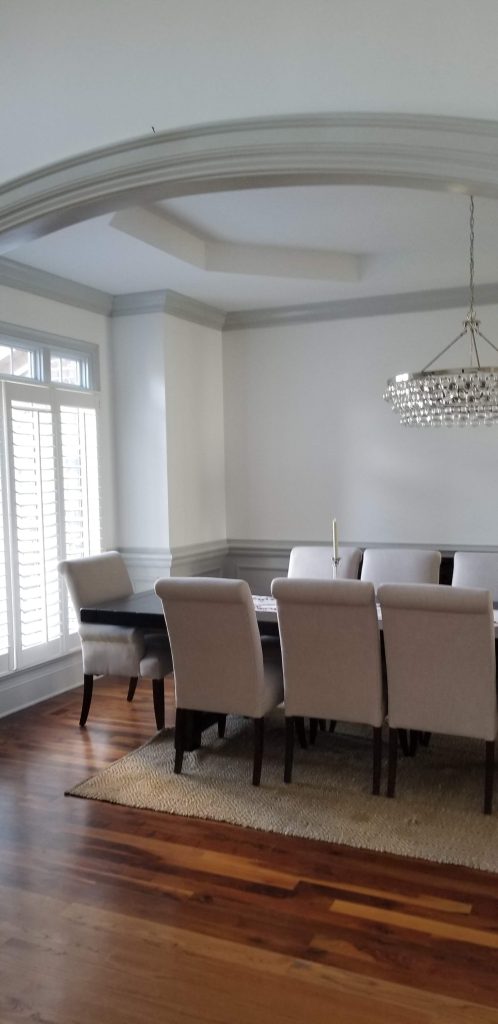 Beautifully painted dining room with light chairs by interior painting services in Charlotte, NC, featuring a modern and elegant design.