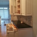 Spacious kitchen with white cabinets, a center island, and modern lighting, highlighting expert cabinet painting in Charlotte, NC.