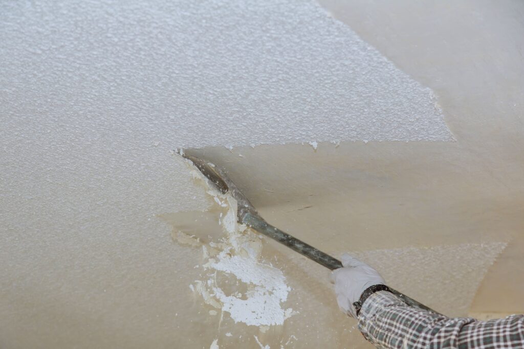 Popcorn ceiling removal in Charlotte, NC by Dubon Painting and More Inc., showing the scraping process